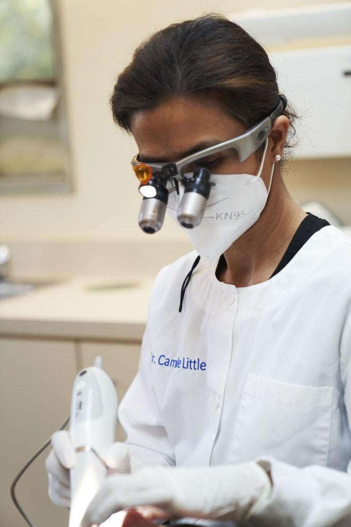 portrait of a dentist holding an intraoral camera